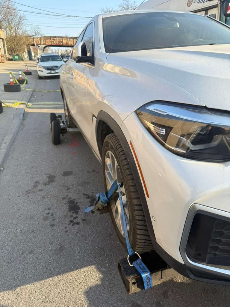 White BMW X6 on JG Towing wheel-lift by the elevated subway tracks in Queens, NY.