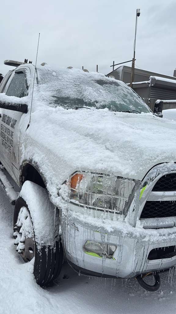 JG Towing Ram wrecker covered in snow and ice after a Queens winter storm.