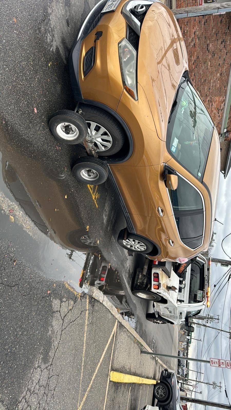 Gold Lexus sedan loaded on JG Towing wheel-lift on a Queens side street.